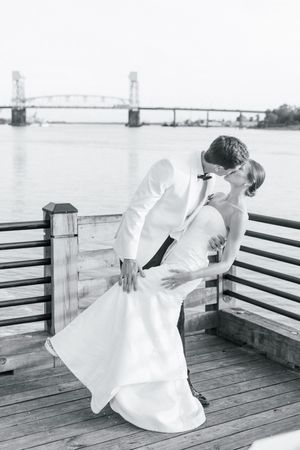 A sequence of black and white photos showing a person in a flowing white dress posing gracefully on a wooden pier.