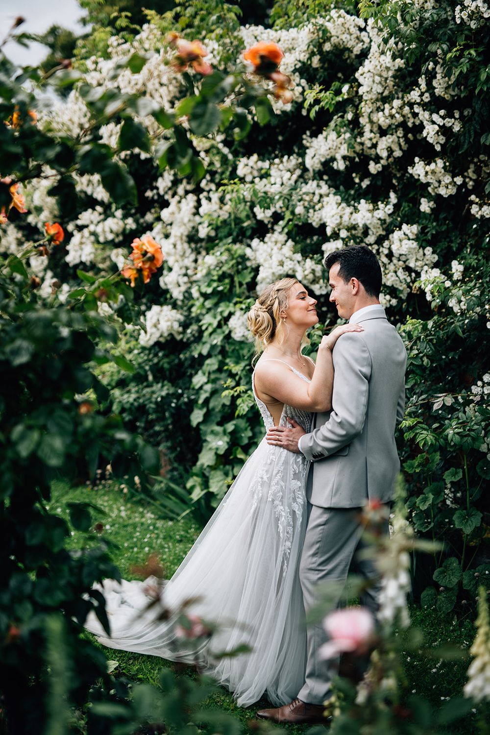 A romantic garden wedding scene with white blossoms and orange flowers creating a beautiful natural backdrop.