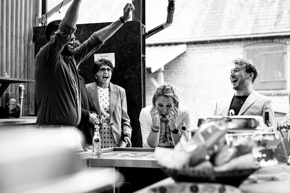 Black and white panoramic series of candid moments at an indoor gathering.