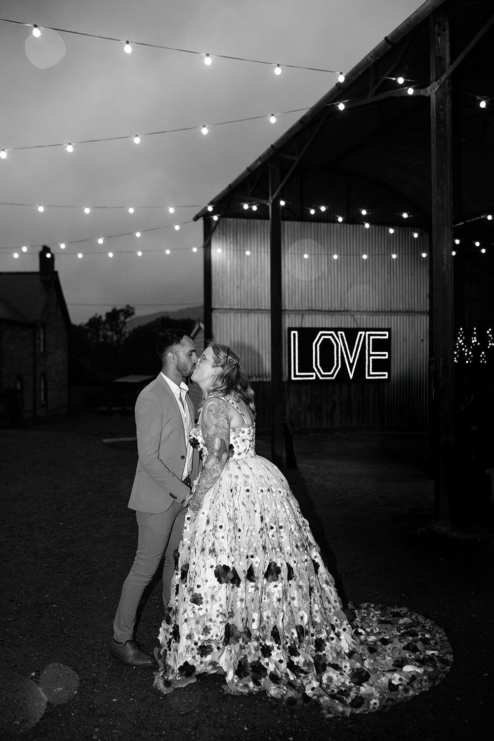String lights illuminate a nighttime scene with a neon LOVE sign in the background.
