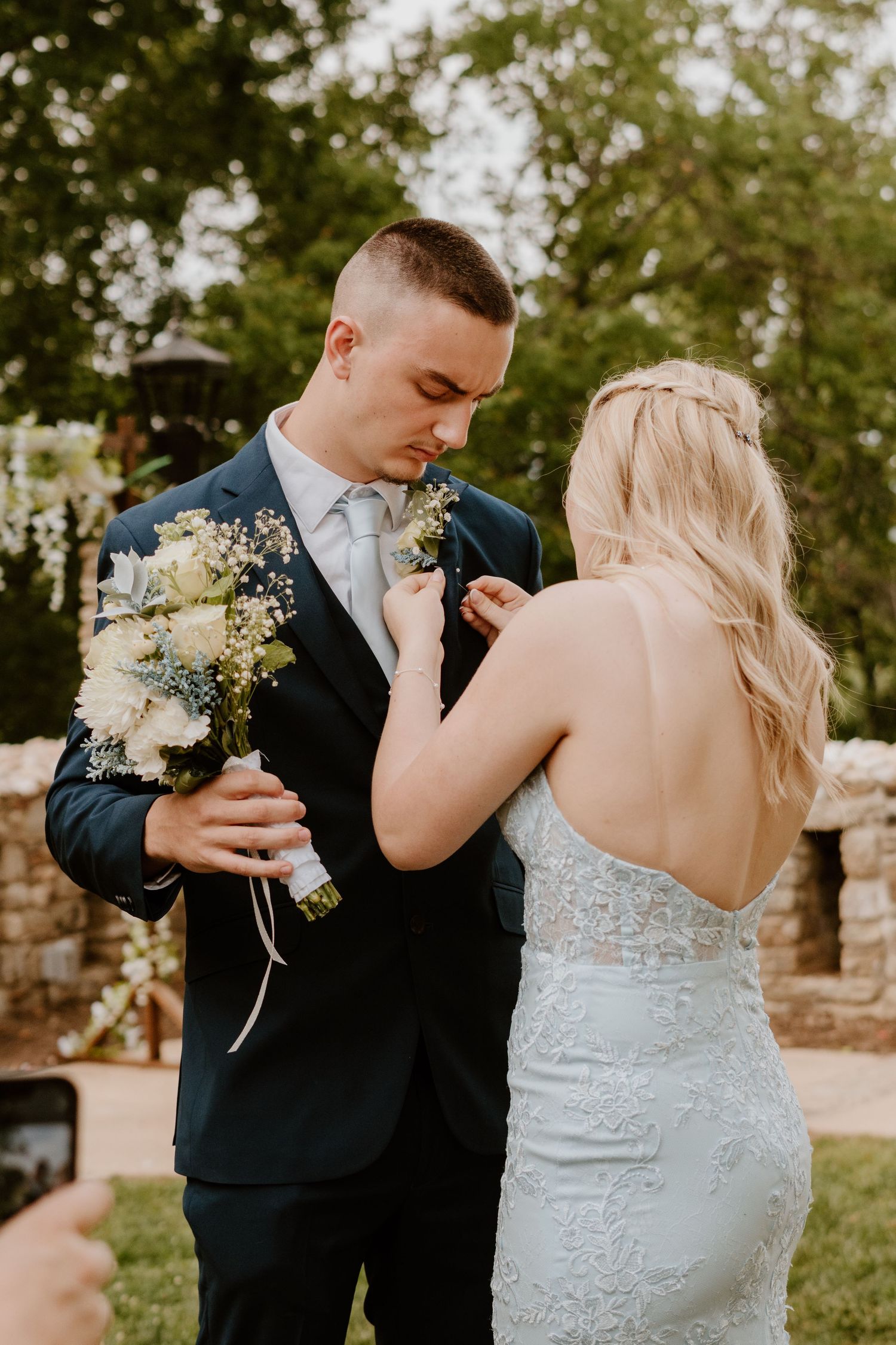 Bride and groom share tender moments during their first look in a garden setting.