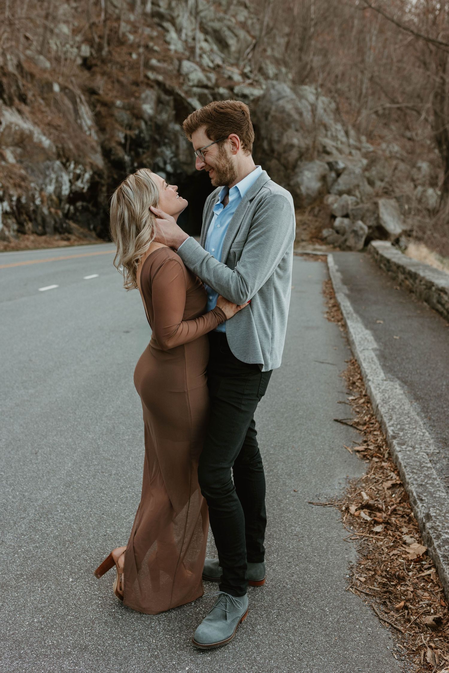 A sweet moment captured on a leaf-covered road during autumn.