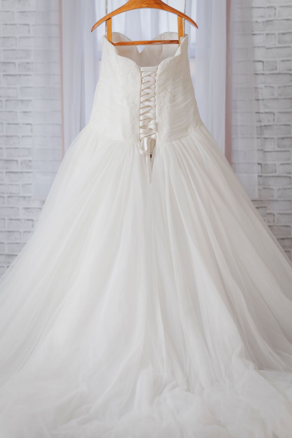 Elegant white wedding dress with corset back detail and flowing tulle skirt shown from multiple angles.