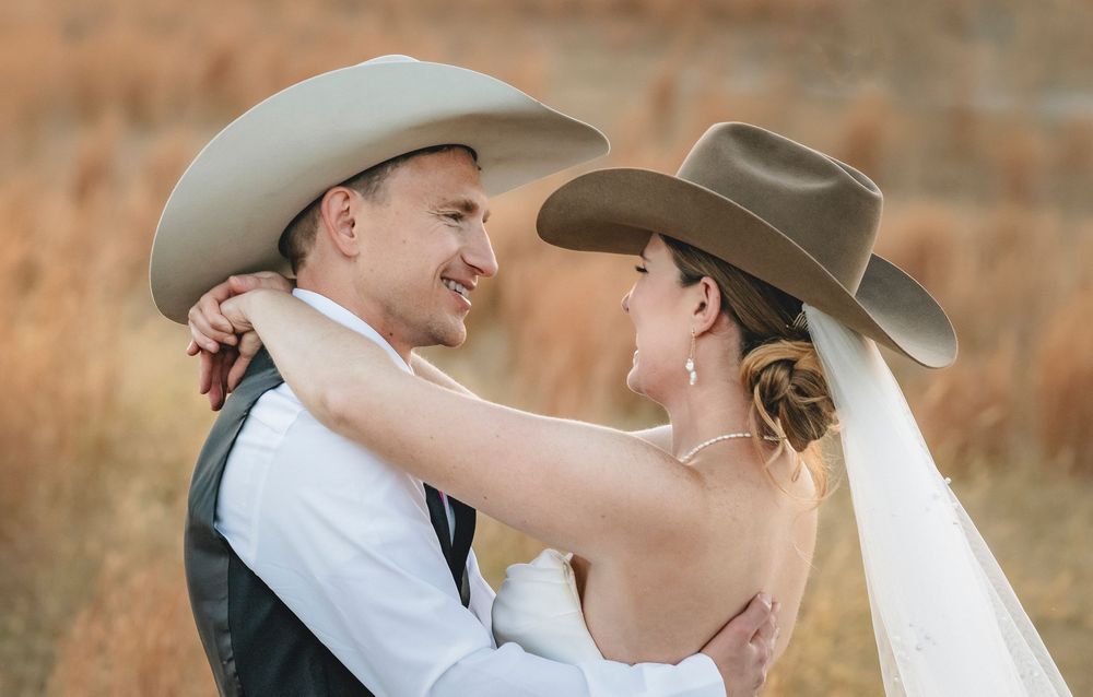 A romantic couple in cowboy hats embraces during a sunset photo session in a golden field.
Wedding in Texas