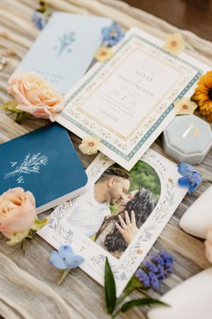 Wedding stationery and invitations decorated with fresh flowers and a blue envelope.