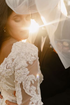 Sunlit close-ups of intricate lace details on wedding gown.