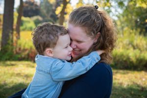 A touching moment of affection between parent and child in an outdoor setting.
