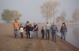 A group of people walking together on a misty beach during an overcast day.