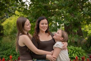Family members share joyful moments together outdoors in a lush green garden setting.