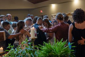 The crowd praying for a couple on their wedding day.