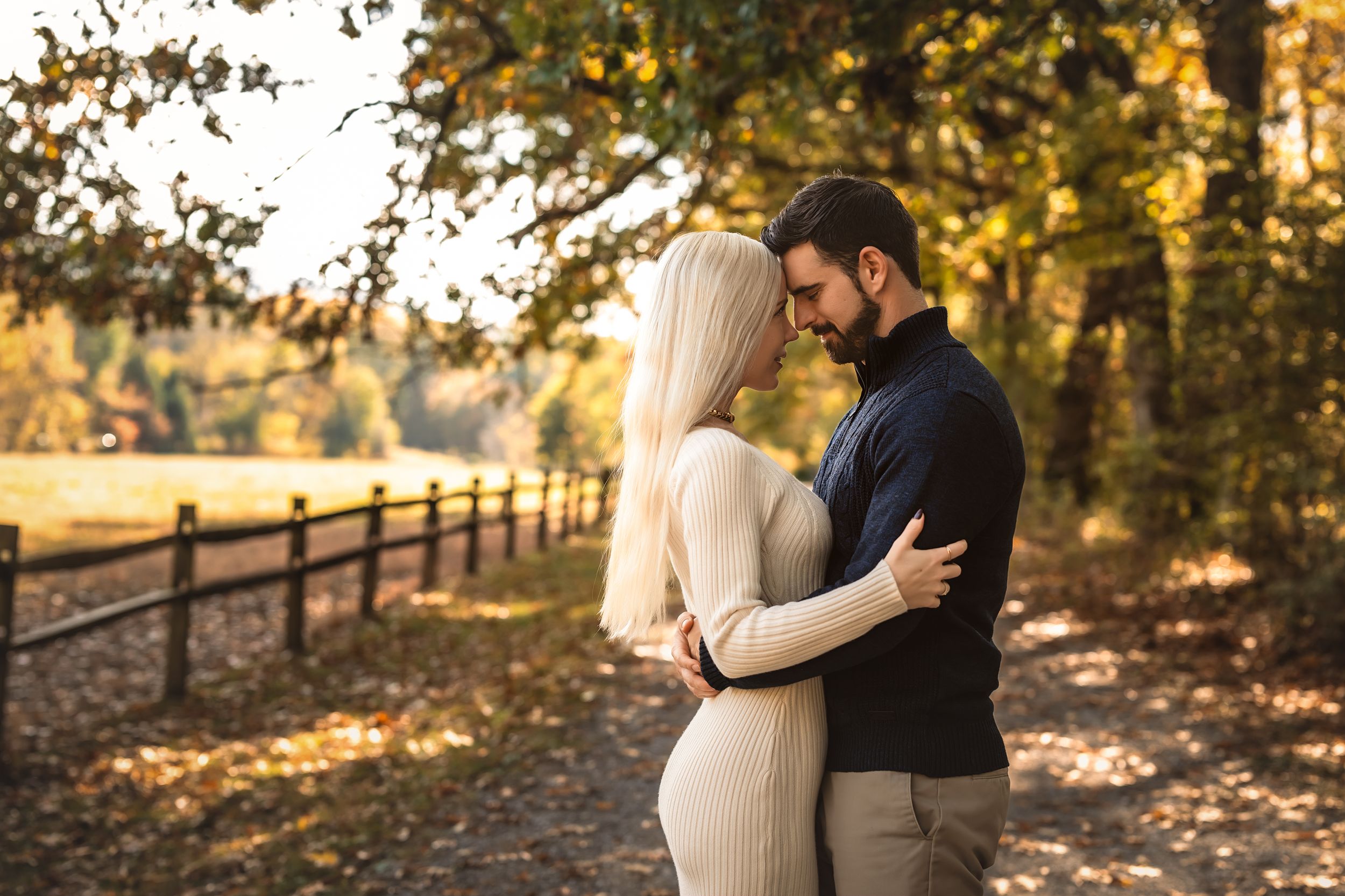 A romantic couple shares intimate moments in a beautiful outdoor setting during golden hour.