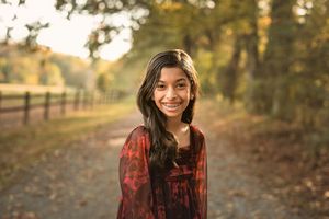Portrait sequence of a woman in a burgundy top smiling against an autumn background.