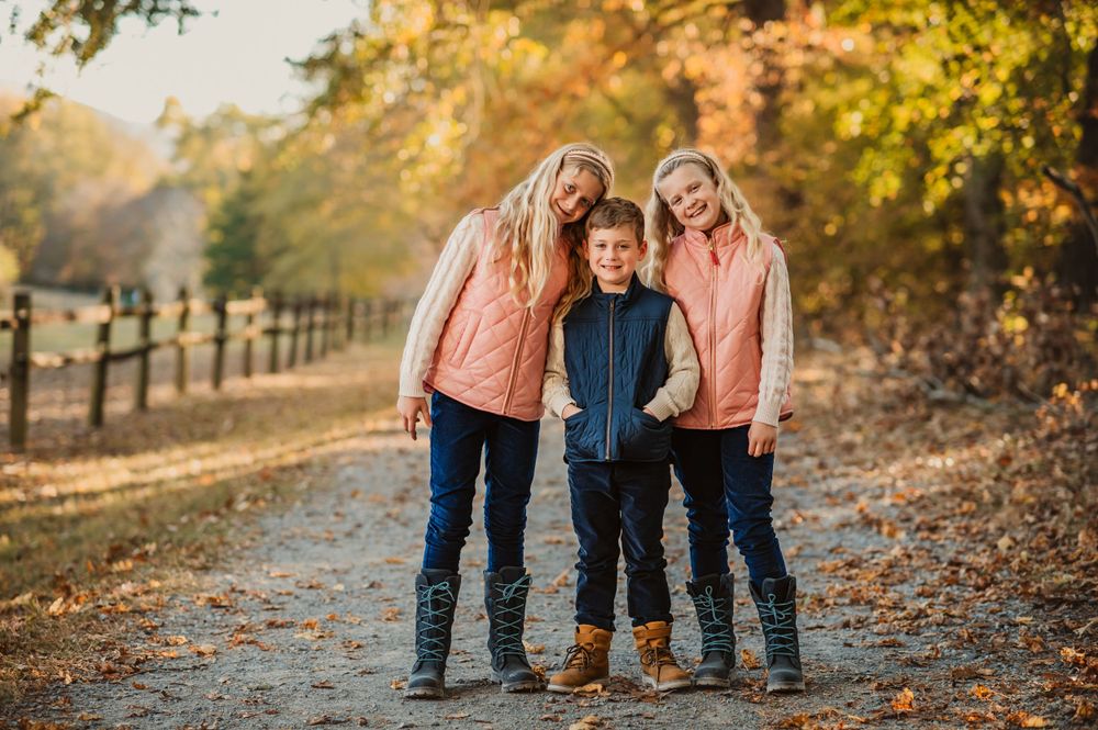 twin girls stand on either side of their little brother for fall mini session photo in Chattanooga