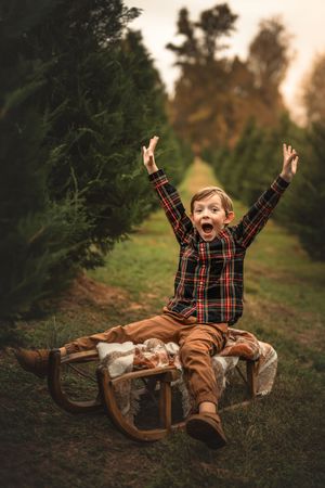 Joyful expressions and laughter captured in a Christmas tree farm setting during golden hour.