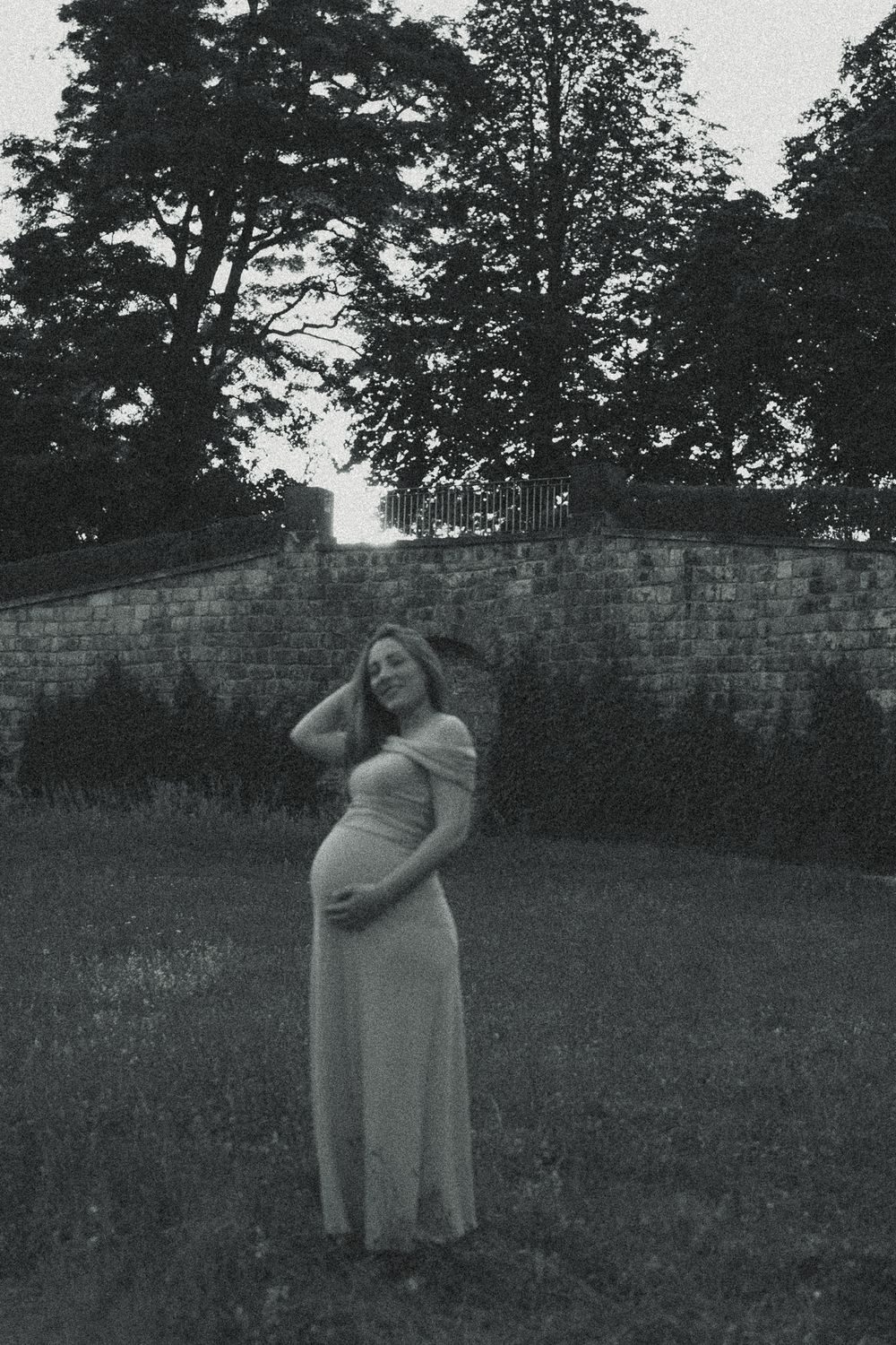Portrait Babybauchfotoshooting - Frau hält ihren schwangeren Bauch und fässt sich durch die Haare im Japanischen Palais Dresden