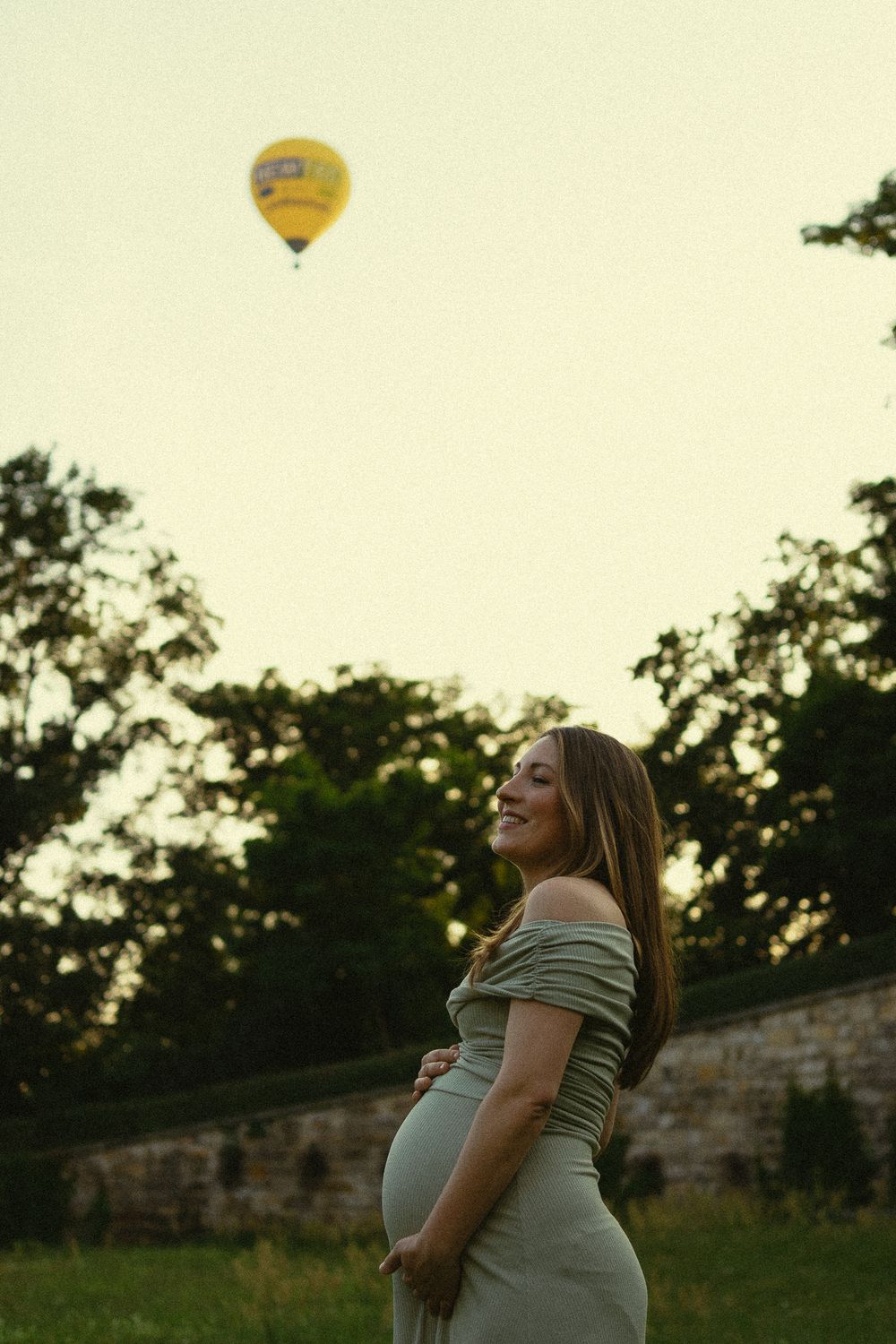 Frau fässt ihren schwangeren Bauch an, am Himmel geht ein Heißluftballon in die Höhe -  Schwangeren Fotografie Japanisches Palais Dresden
