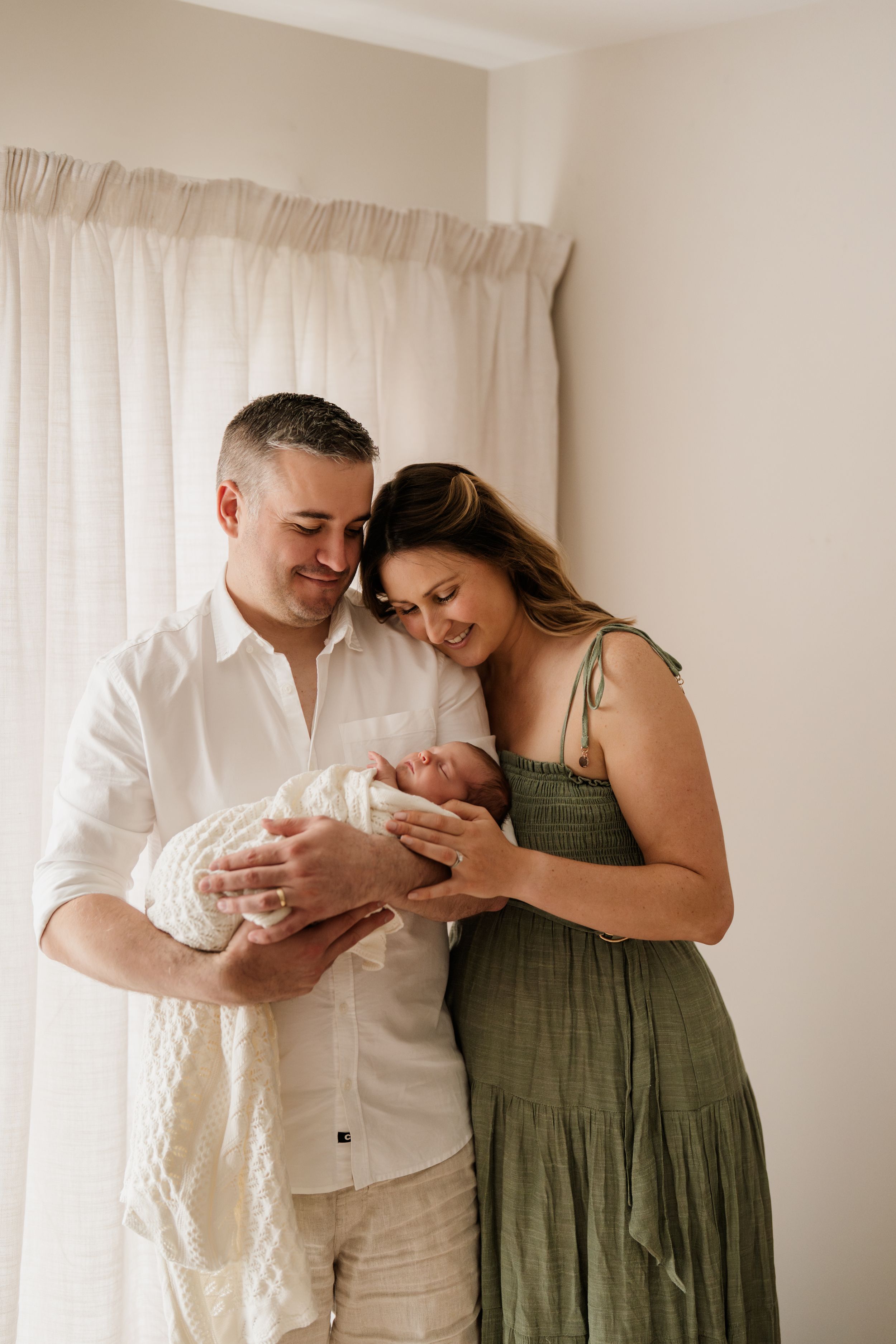Parents admiring their newborn baby during an in-home lifestyle newborn photography session