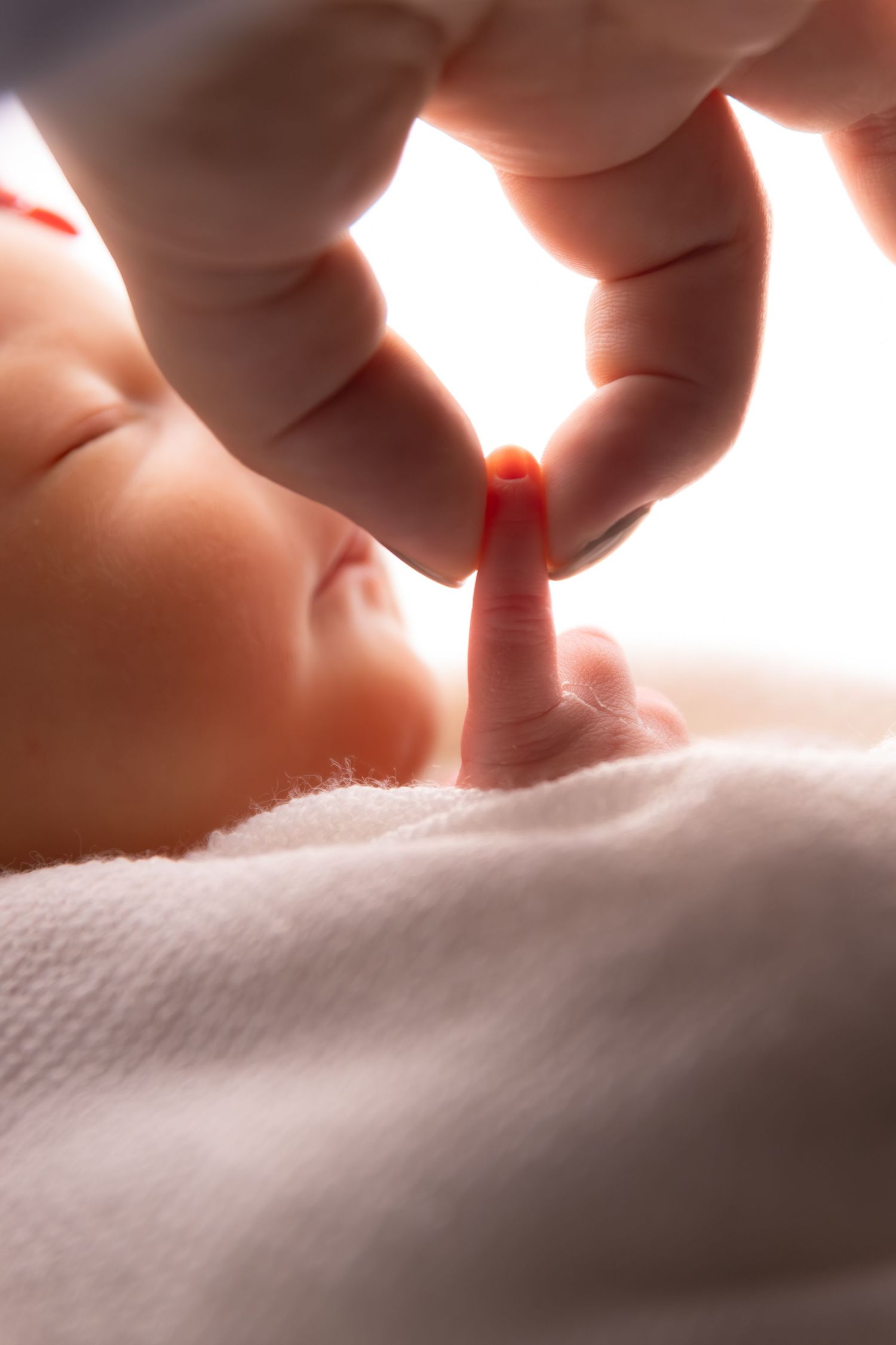Artistic macro shots of tiny newborn toes against soft white textured fabric.