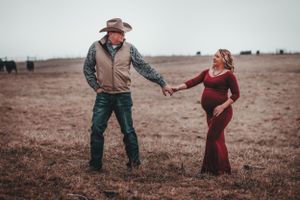 Couple dancing in an open field during golden hour.