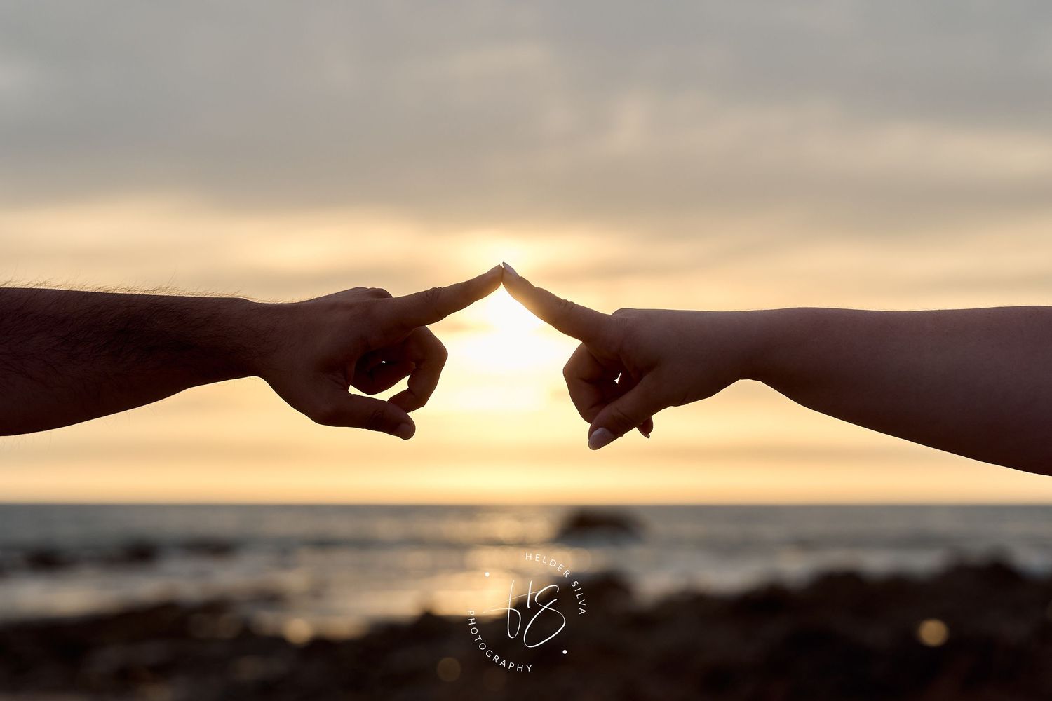 dedos dos namorados a tocar ao por do sol