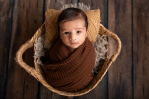 Wide awake baby boy in a basket photographed in Newton NJ Photography Studio
