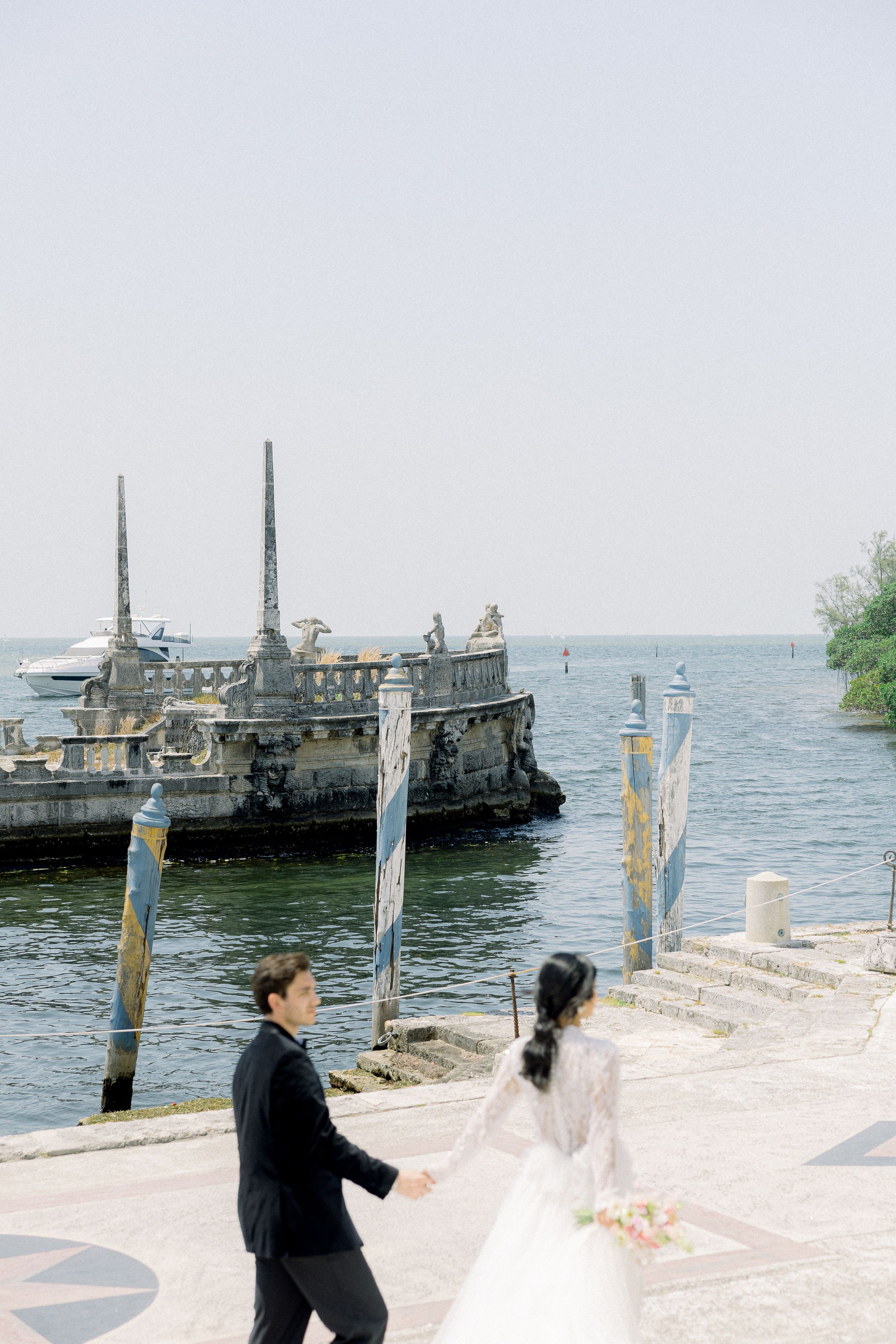 Romantic waterfront wedding scene with historic ships and coastal architecture.