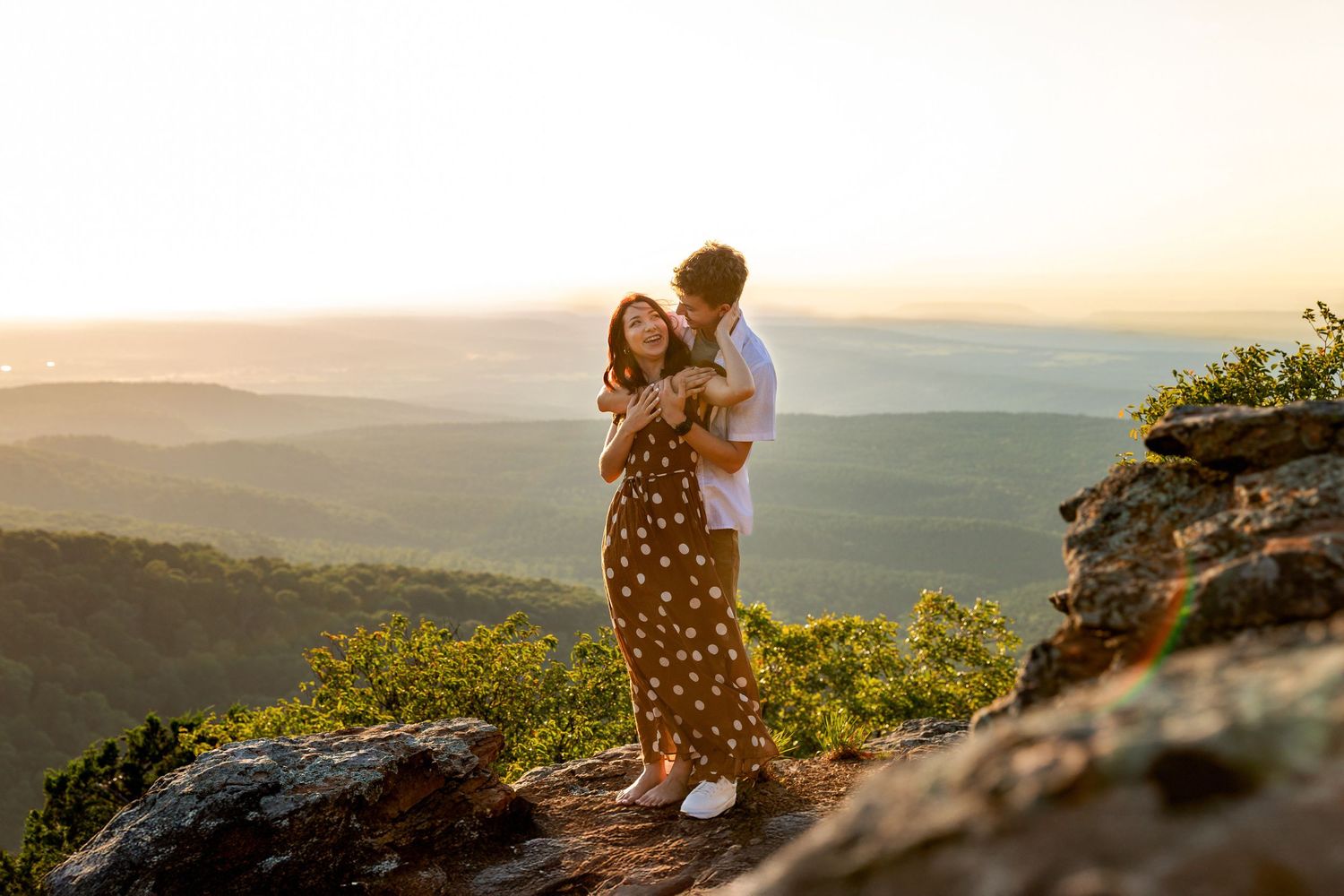 Romantic couple embracing in vintage chair among tall grass field.