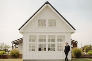 Minimalist white wedding venue with large windows and classic architectural details.