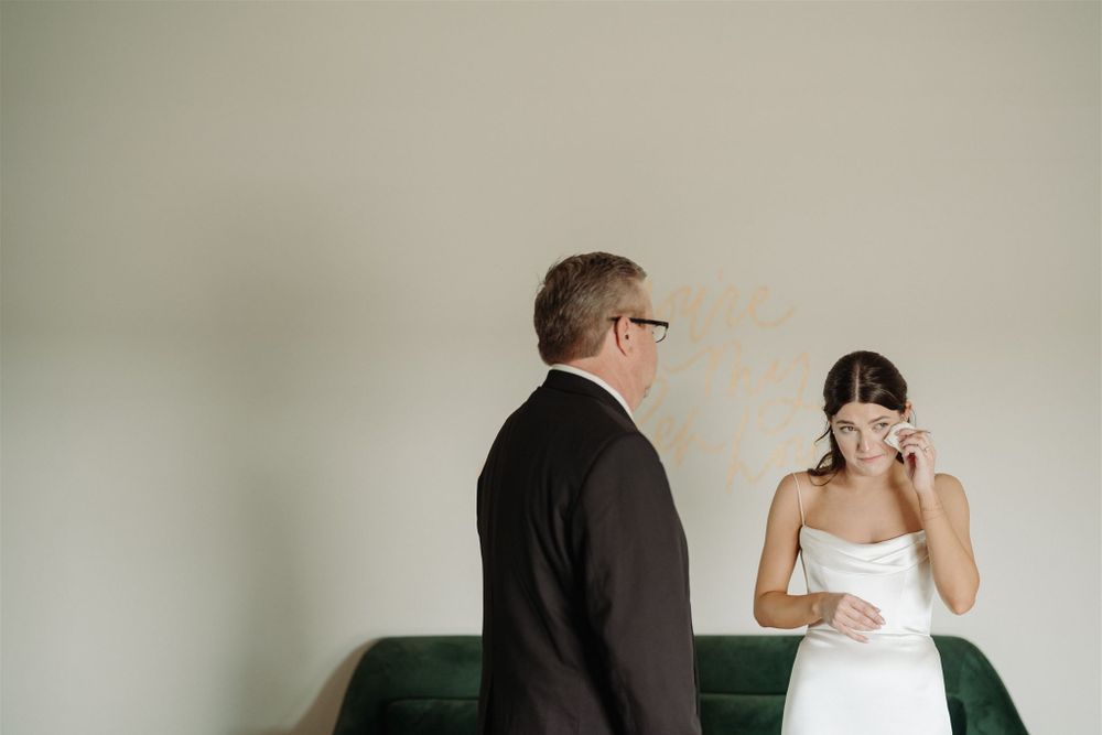Intimate emotional moment during wedding preparations indoors.