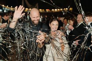 Guests celebrating at an outdoor evening event with sparklers and string lights creating a festive atmosphere.