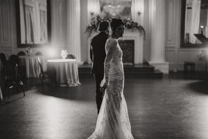 A black and white photo of newlyweds sharing a romantic moment together on the dance floor at their wedding reception.