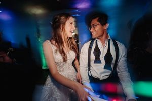 Wedding reception with dancers moving on the dance floor under vibrant blue and multicolored lights.
