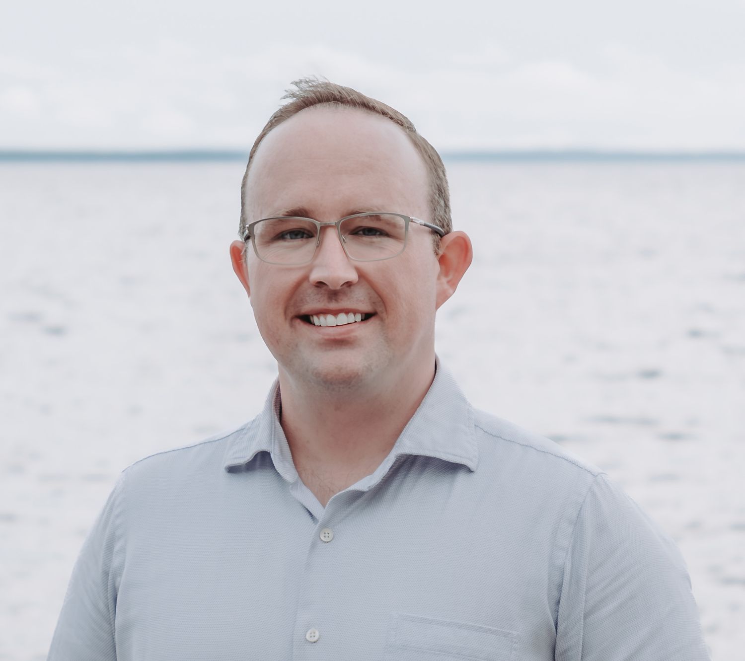 Professional headshots of a person wearing glasses and a light gray collared shirt against a bright background.