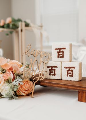 Wooden table numbers with elegant rose gold lettering and peach roses create a romantic wedding table setting.