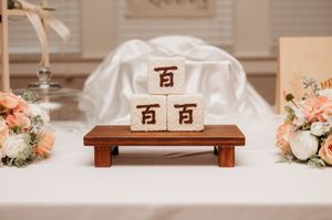 A series of wedding decor details with Chinese characters, floral arrangements, and wooden accents in warm neutral tones.