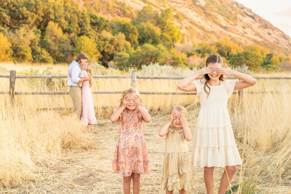 Family having fun together outdoors in field with mountain backdrop at sunset at Hidden Valley Park.