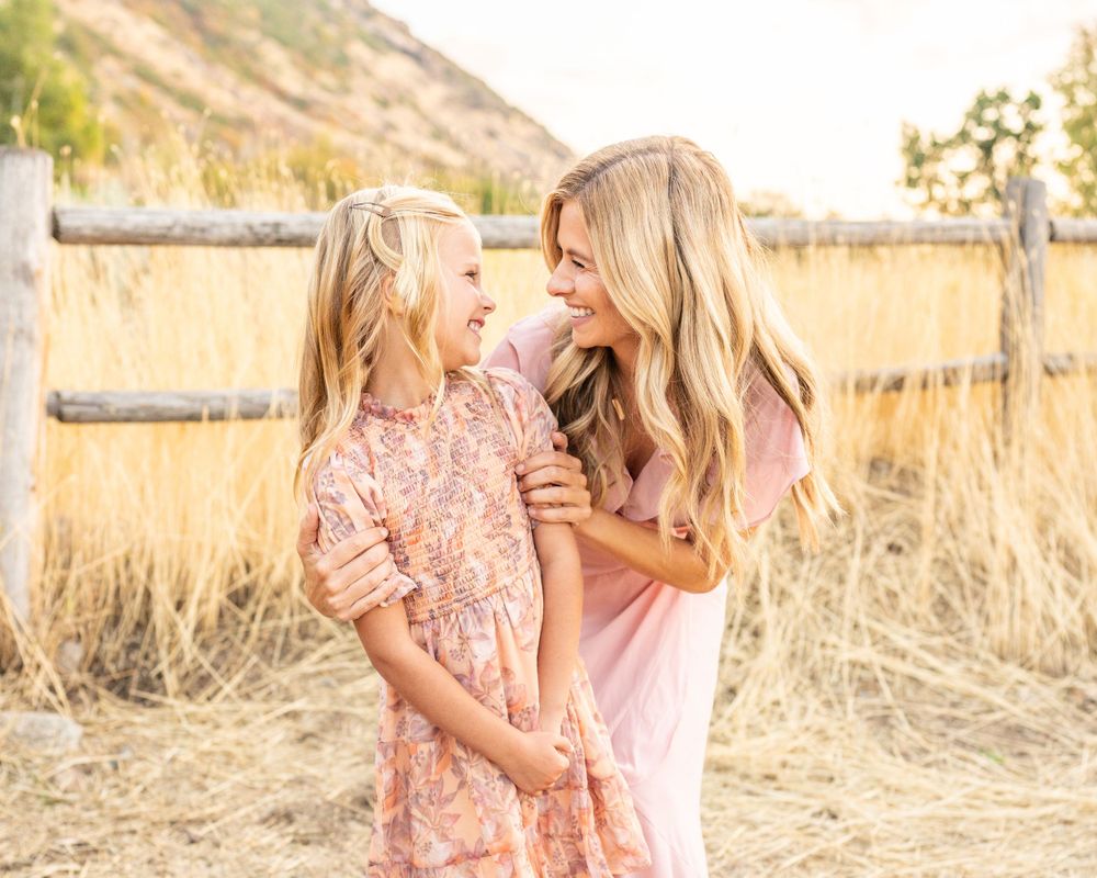 Joyful moment shared between two people in flowing dresses against mountain landscape at Hidden Valley Park.