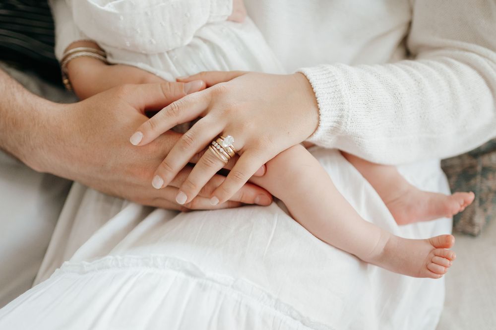 Close up detail shots of baby's tiny hands and feet with parent's hands.