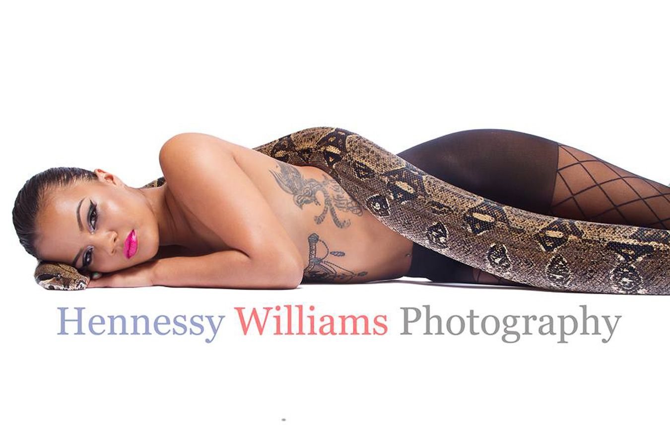 Model poses elegantly on floor wearing a patterned dress in a professional studio photography session.