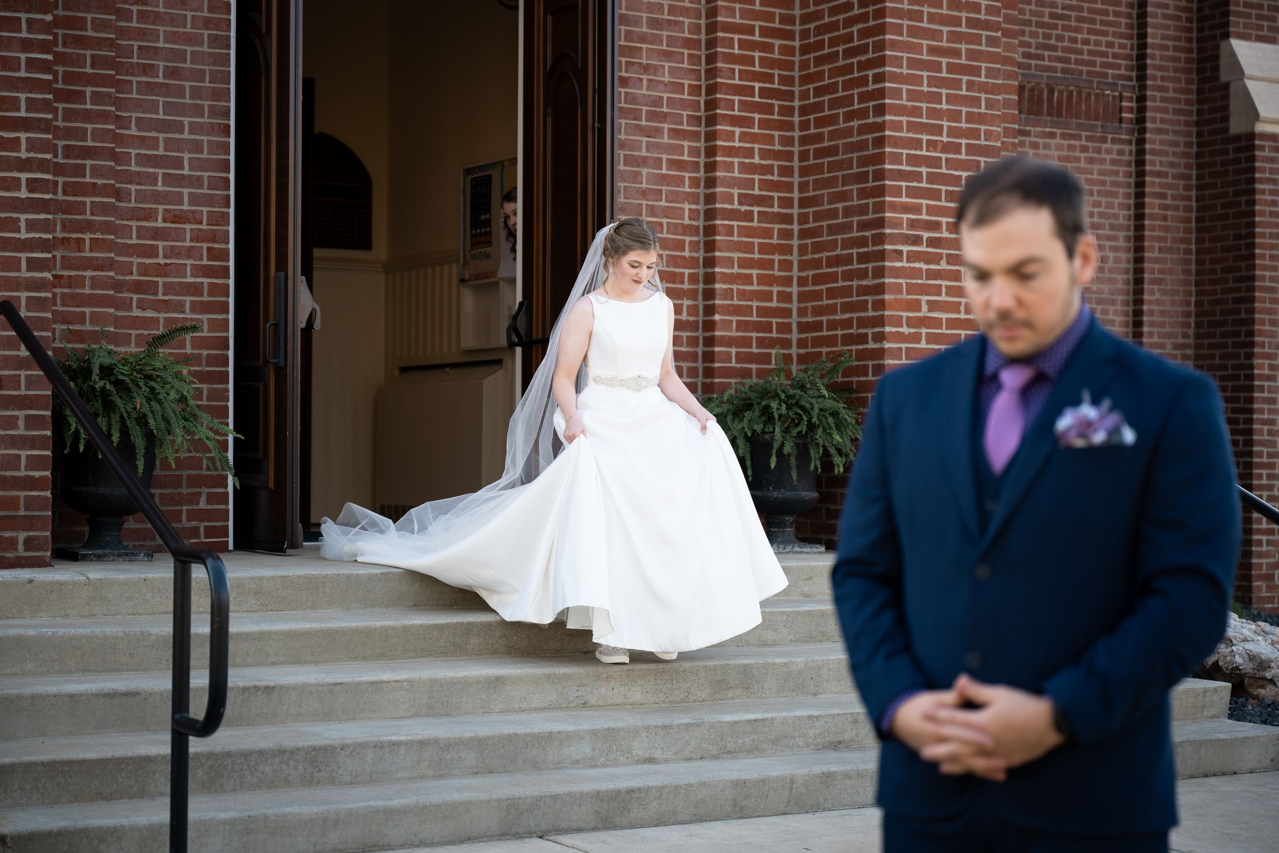 A wedding ceremony procession along brick church steps with the couple and attendants in formal attire.