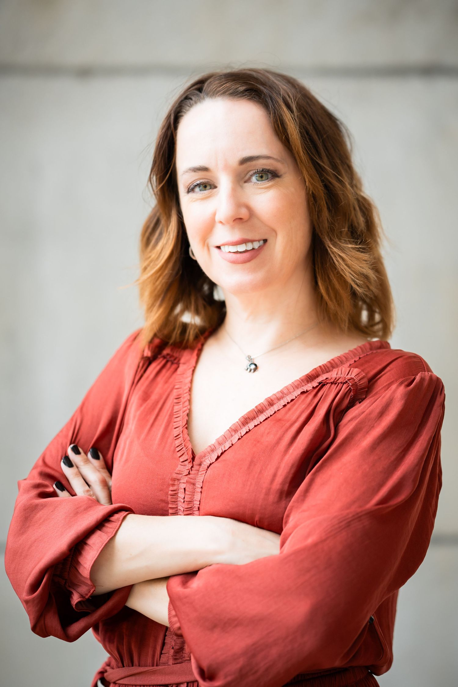 Professional headshots of a person in a rust-colored blouse posing against a light gray background.
