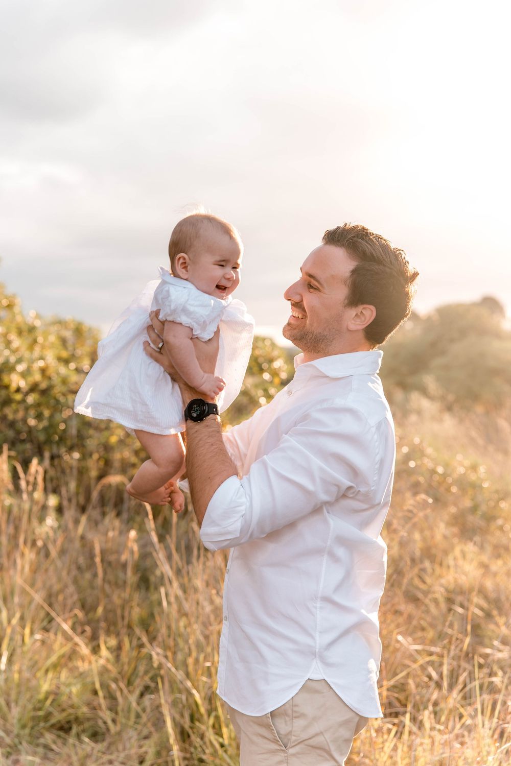 Father and daughter laughing at golden hour