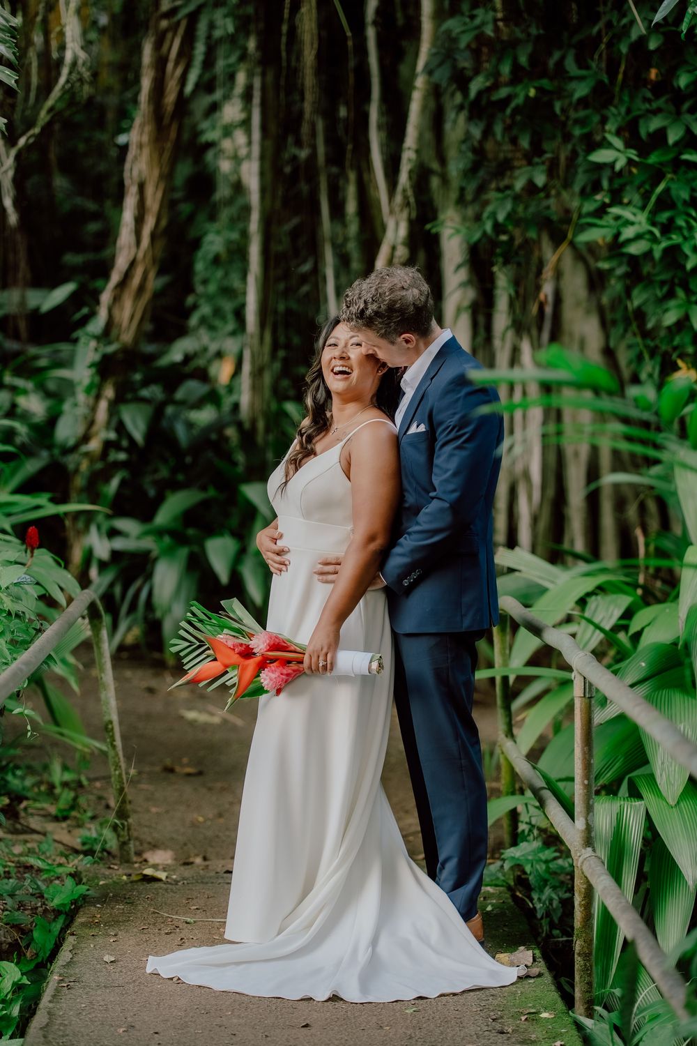 Romantic wedding couple shares intimate moments in a lush green forest setting with natural lighting.
