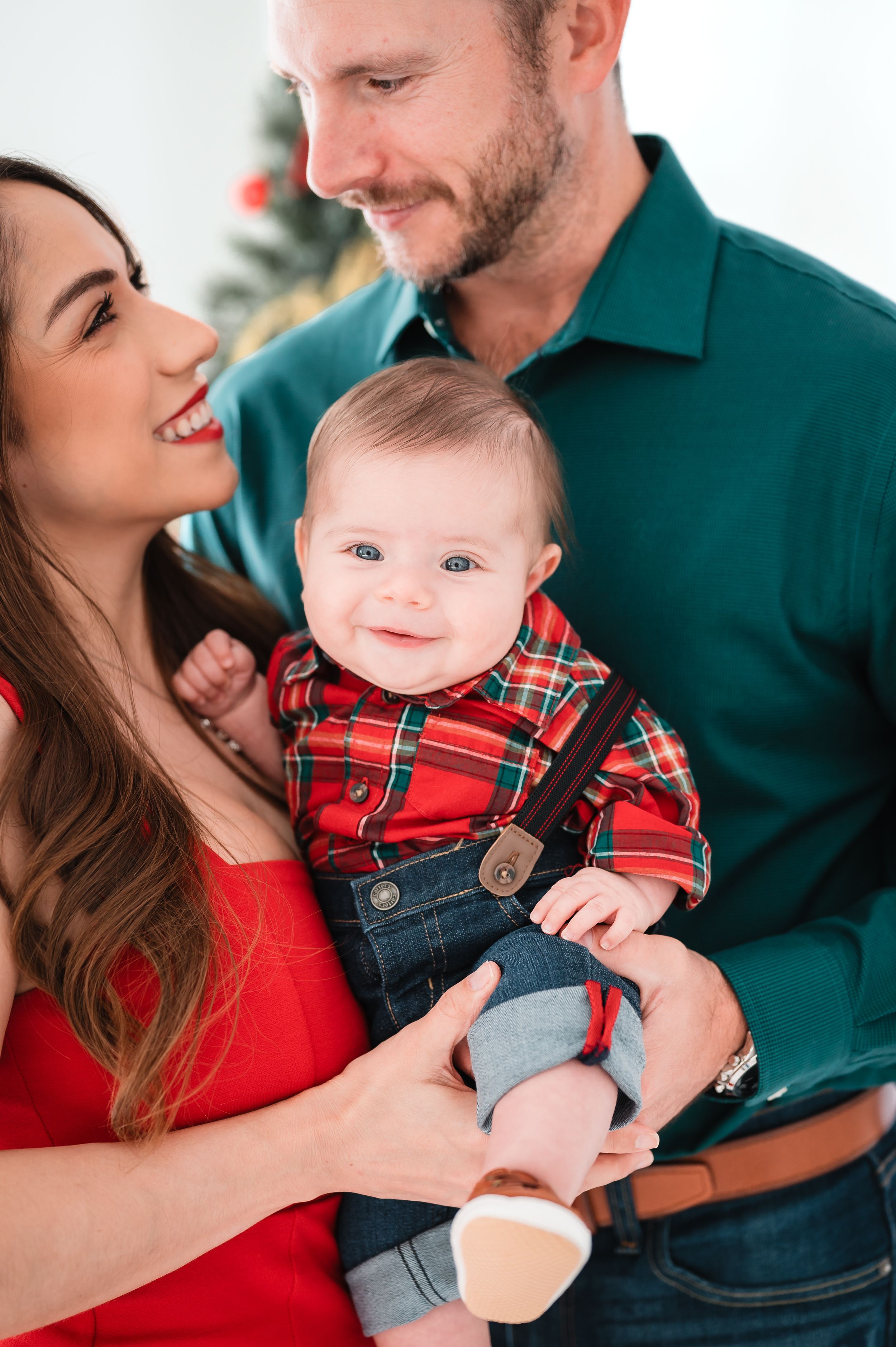 Holiday family photos featuring plaid and red outfits with festive Christmas styling.