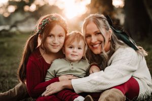 Cozy family photography session with burgundy and white sweaters in warm autumn lighting.