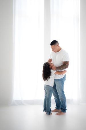 Candid family portrait session showing joyful moments and movement against bright white background.
