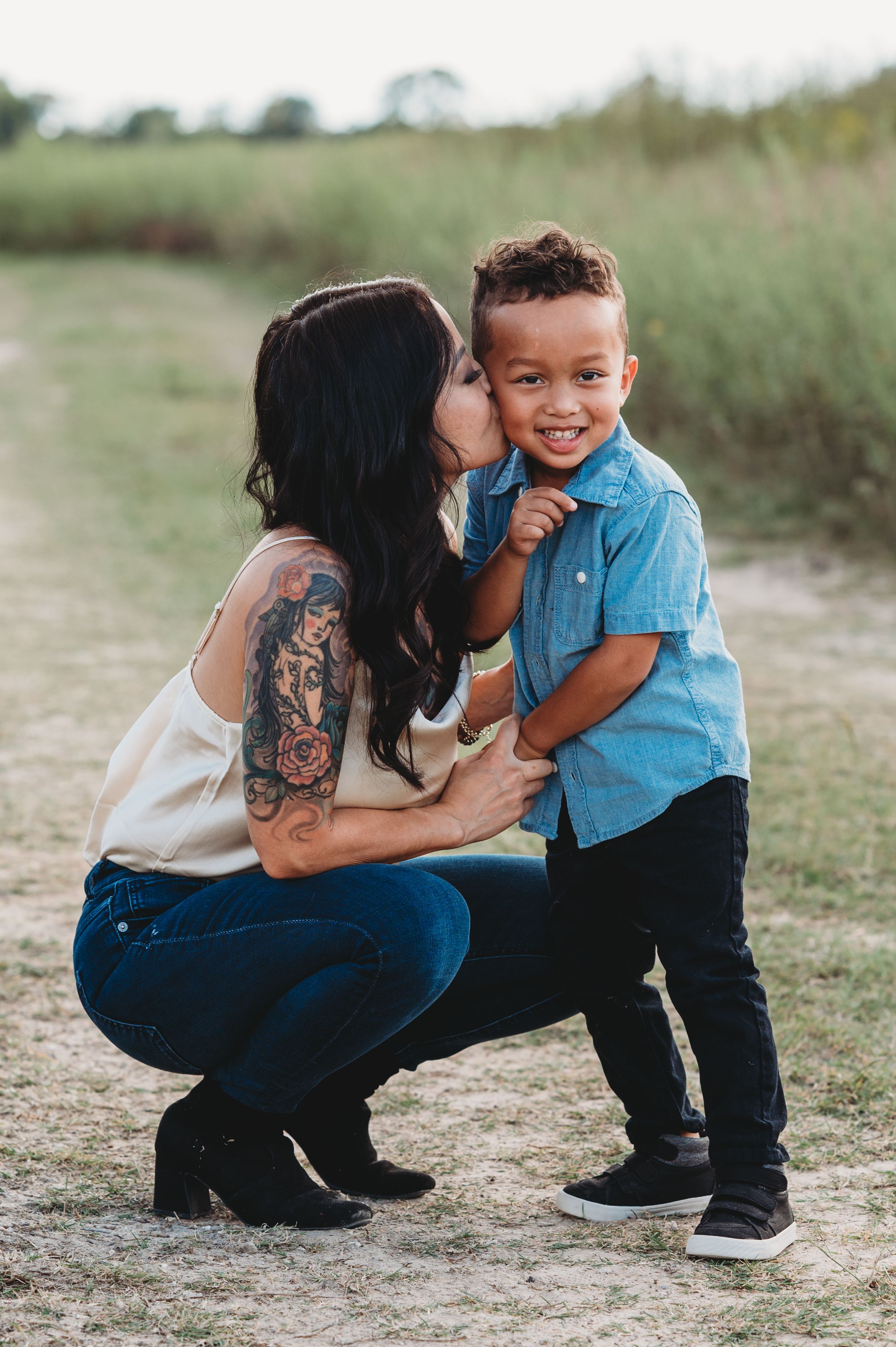 Mother and child share playful moments together outdoors in casual clothing.