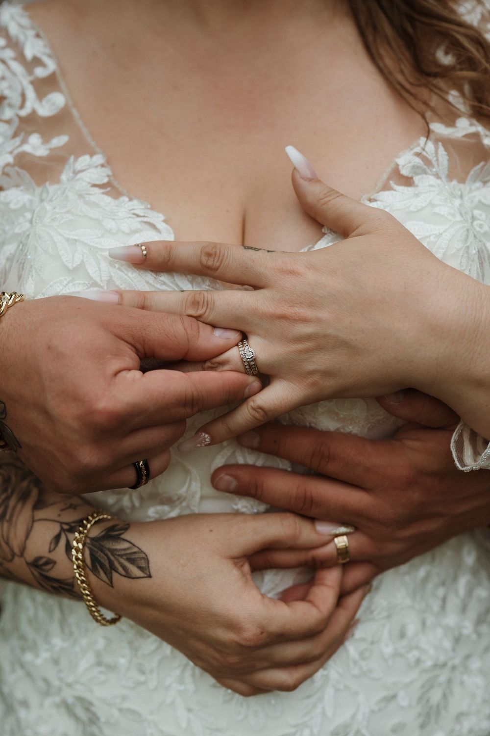 Close-up sequence of hands exchanging wedding rings during a ceremony against white lace fabric background.