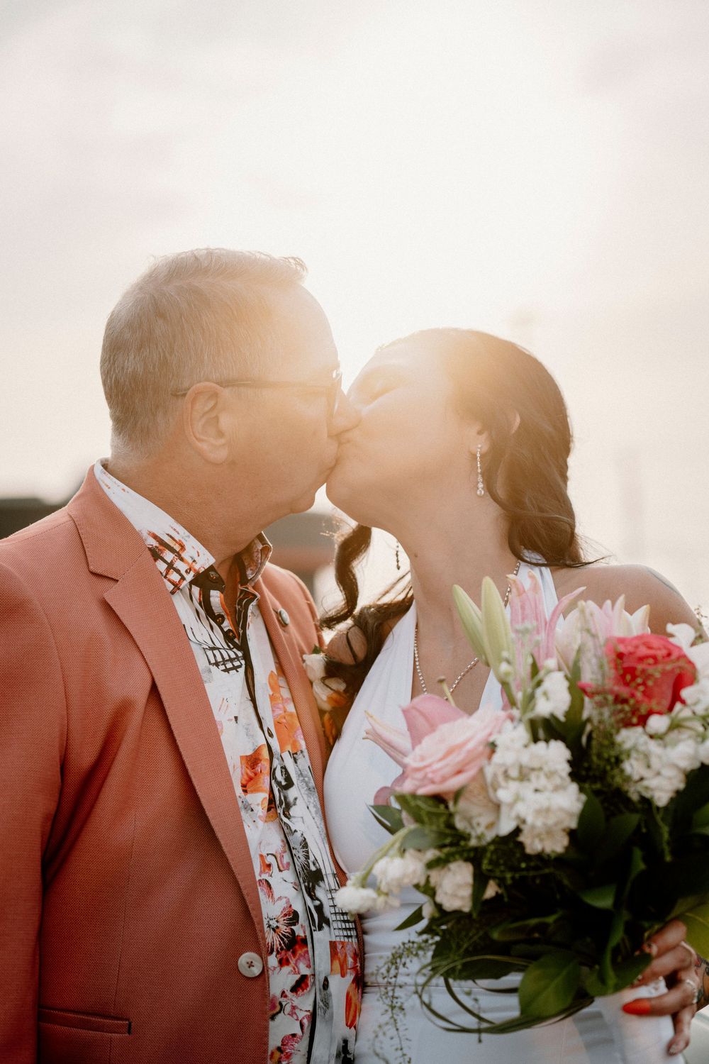 A romantic wedding photo series showing a couple in silhouette sharing tender moments against warm sunlight.