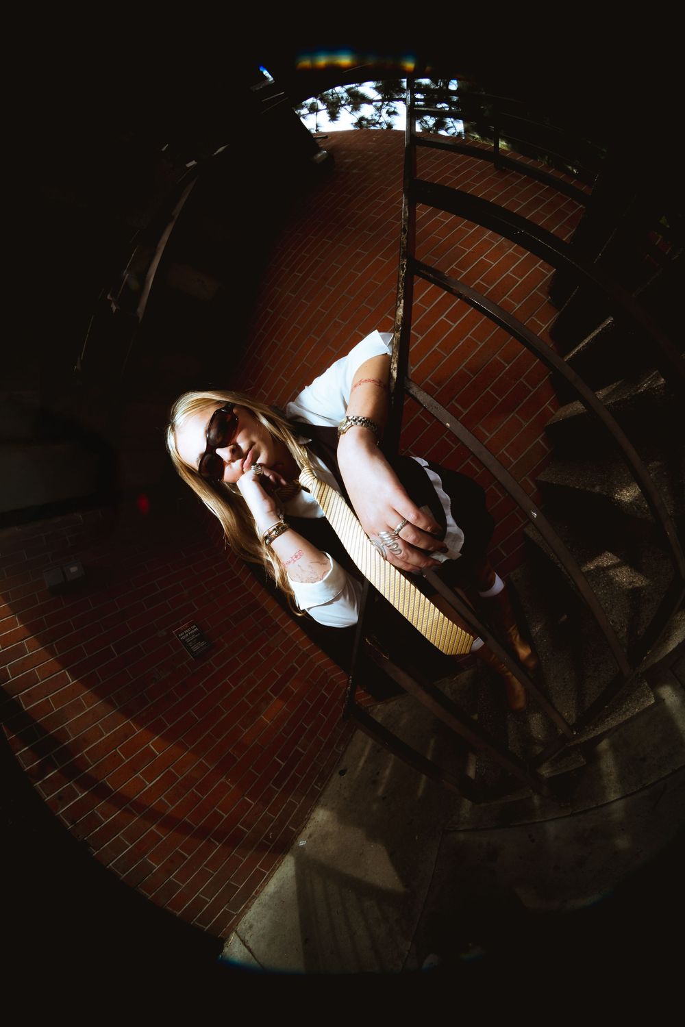 A woman poses in front of a camera on a railing. This wide angle shot lets you see a vivid background while making the subject stand out